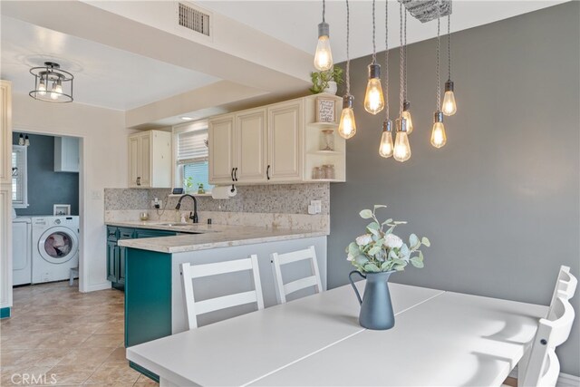 14844 Lull St, Van Nuys, CA 91405 - kitchen with visible vents, open shelves, light countertops, backsplash, and washing machine and clothes dryer
