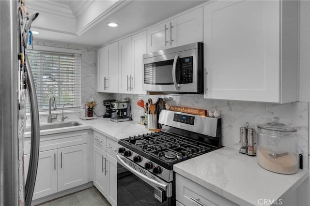 9876 Arrow Unit 1, Rancho Cucamonga, CA 91730 - kitchen featuring appliances with stainless steel finishes, a sink, crown molding, white cabinetry, and backsplash