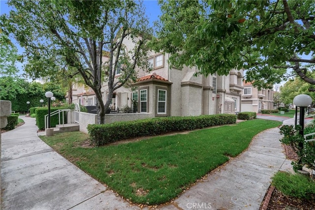 9876 Arrow Unit 1, Rancho Cucamonga, CA 91730 - view of property exterior with stucco siding and a lawn