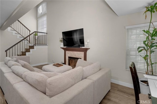 9876 Arrow Unit 1, Rancho Cucamonga, CA 91730 - living room with wood finished floors, baseboards, a high end fireplace, and stairs