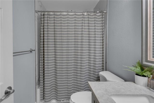 9876 Arrow Unit 1, Rancho Cucamonga, CA 91730 - full bathroom with toilet, vanity, shower / tub combo with curtain, and a textured wall
