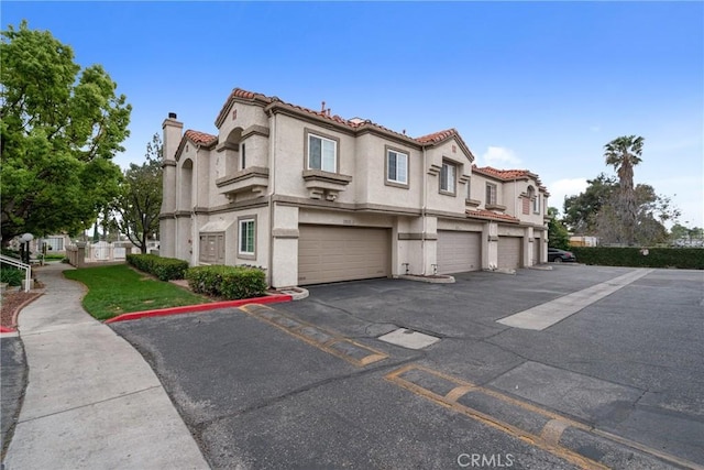 9876 Arrow Unit 1, Rancho Cucamonga, CA 91730 - view of front facade featuring driveway, a garage, a tile roof, and stucco siding