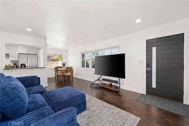 living room featuring recessed lighting, dark wood-style floors, and baseboards