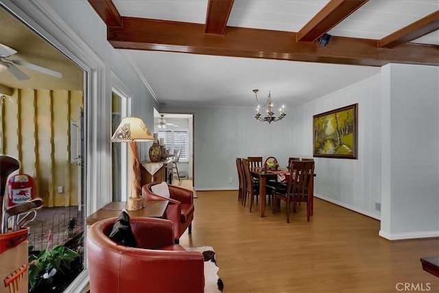 dining room featuring crown molding, ceiling fan with notable chandelier, wood finished floors, and beam ceiling