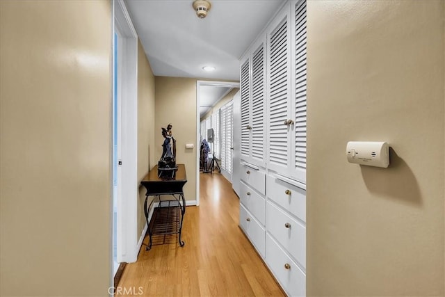 hall featuring light wood-style floors, baseboards, and recessed lighting