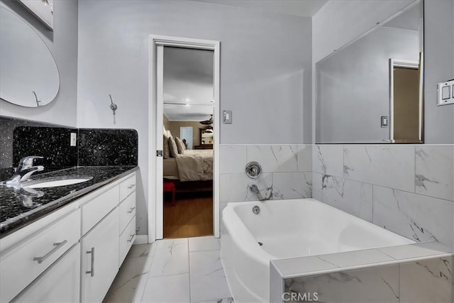 ensuite bathroom with a bath, marble finish floor, ensuite bath, and vanity