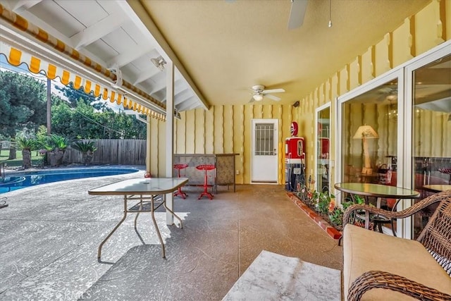 view of patio / terrace with fence, a fenced in pool, and a ceiling fan