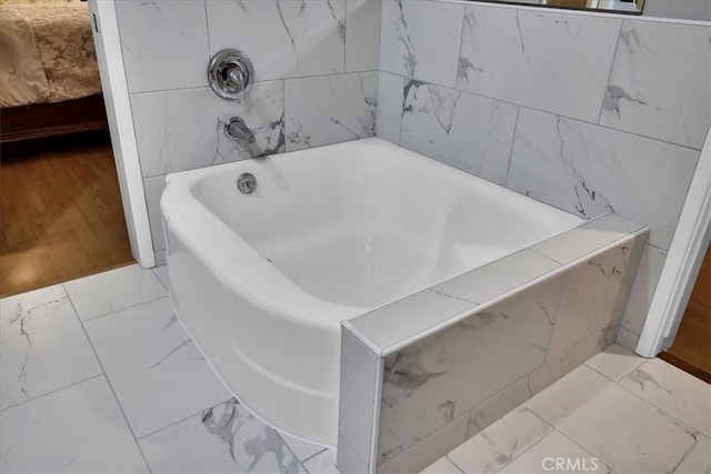 full bathroom featuring a tub to relax in and marble finish floor