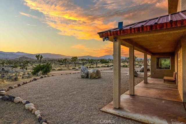 53105 Chia Trl, Pioneertown, CA 92268 - yard at dusk featuring a mountain view and a patio
