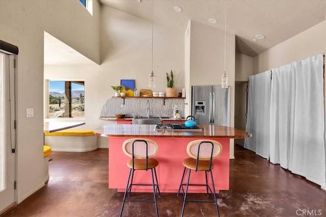 53105 Chia Trl, Pioneertown, CA 92268 - kitchen with high vaulted ceiling, finished concrete floors, a kitchen island, appliances with stainless steel finishes, and a sink