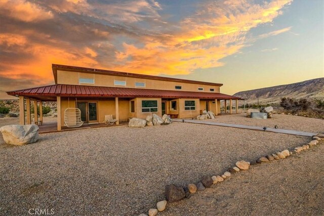 53105 Chia Trl, Pioneertown, CA 92268 - back of house at dusk with metal roof and stucco siding