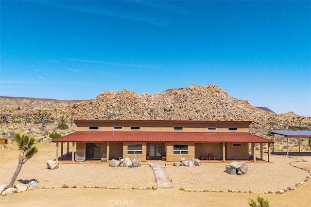 53105 Chia Trl, Pioneertown, CA 92268 - rear view of house with a carport, a mountain view, and stucco siding