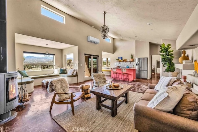 53105 Chia Trl, Pioneertown, CA 92268 - living area featuring concrete flooring, a wood stove, a wealth of natural light, and a wall unit AC
