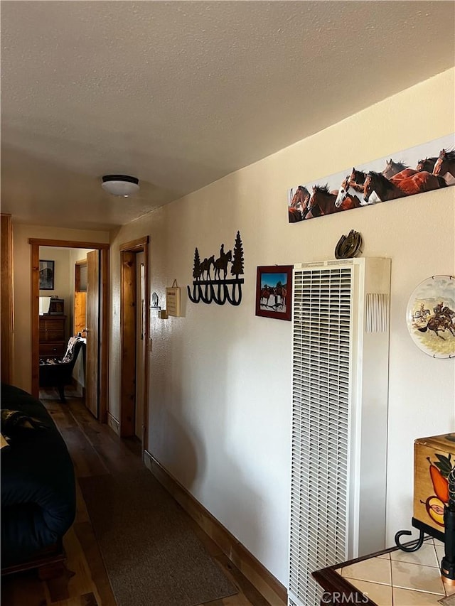 hallway featuring baseboards and a heating unit