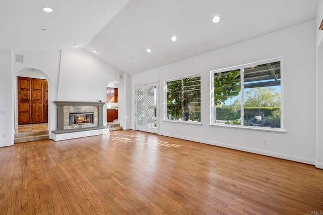 4033 Keri Way, Fallbrook, CA 92028 - unfurnished living room with arched walkways, lofted ceiling, a glass covered fireplace, wood finished floors, and recessed lighting