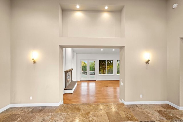 4033 Keri Way, Fallbrook, CA 92028 - unfurnished living room with baseboards, a warm lit fireplace, a towering ceiling, stone finish flooring, and recessed lighting