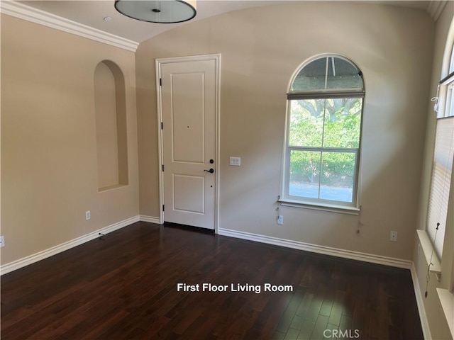 foyer entrance with dark wood-style floors, baseboards, arched walkways, and crown molding