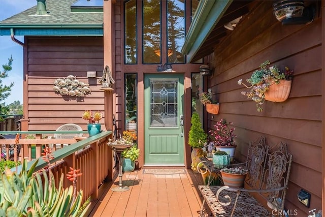 property entrance featuring roof with shingles