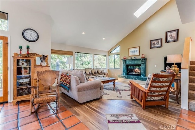 living room featuring light wood-style flooring, high vaulted ceiling, a fireplace, and recessed lighting