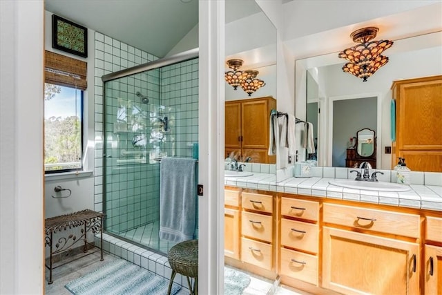 bathroom featuring vanity, a stall shower, and lofted ceiling