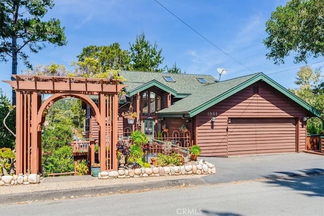 log home featuring a garage and a shingled roof