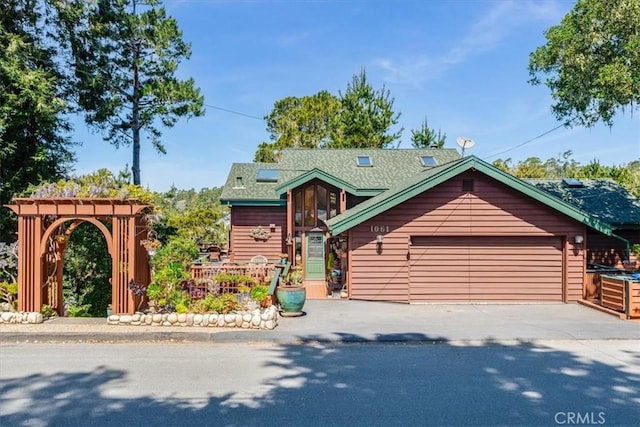 log-style house with a garage, a pergola, and concrete driveway