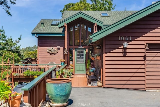 property entrance featuring roof with shingles