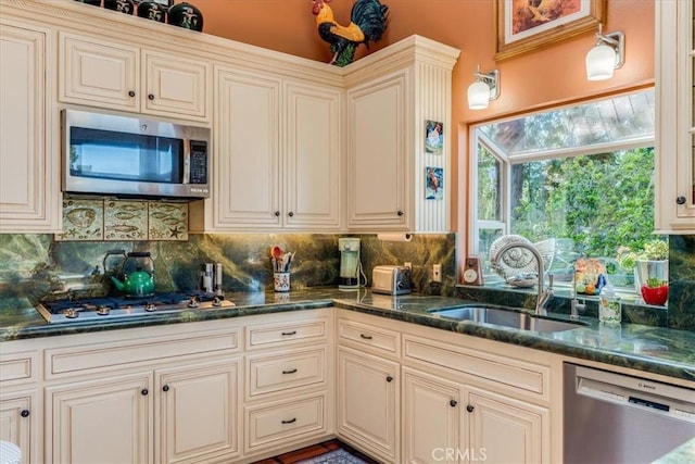 kitchen featuring cream cabinetry, decorative backsplash, a sink, and stainless steel appliances