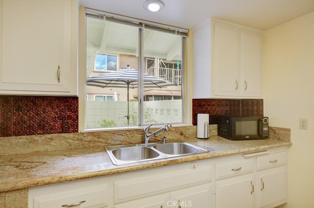 523 Calle Aragon Unit C, Laguna Woods, CA 92637 - kitchen with decorative backsplash, a sink, white cabinets, and black microwave