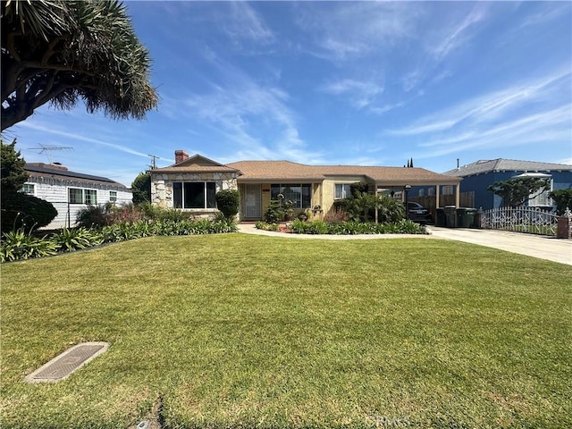 ranch-style home with concrete driveway, fence, a chimney, and a front yard