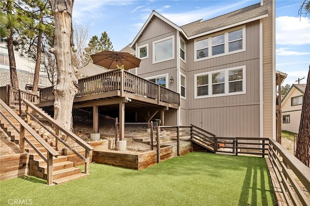 back of house featuring a yard, fence, stairs, a wooden deck, and roof with shingles