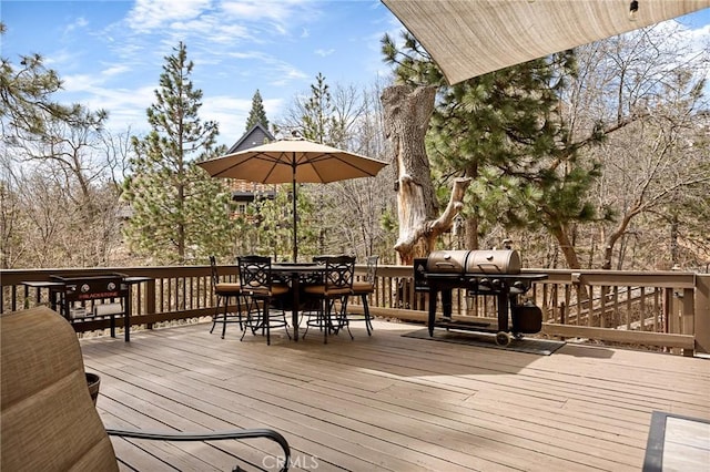 deck featuring outdoor dining area and a grill