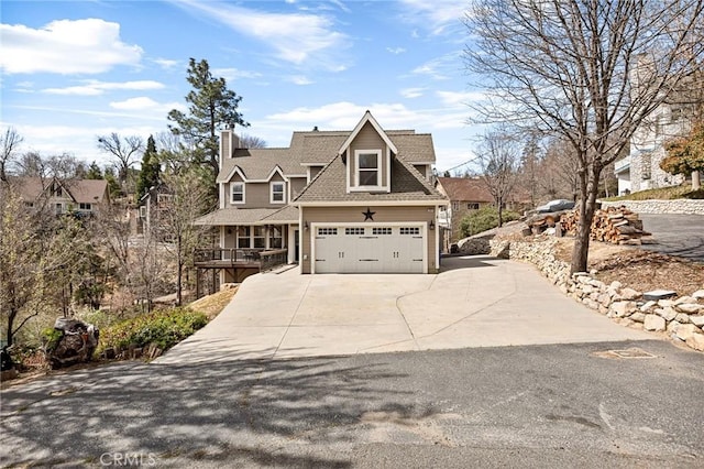 view of front facade featuring concrete driveway, a shingled roof, an attached garage, and covered porch