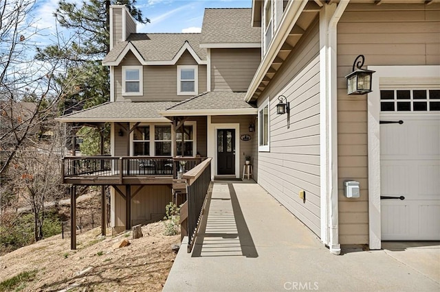 view of front of home with a porch, a shingled roof, an attached garage, and a chimney