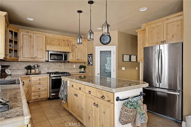 kitchen featuring light tile patterned floors, a center island, light brown cabinetry, stainless steel appliances, and backsplash