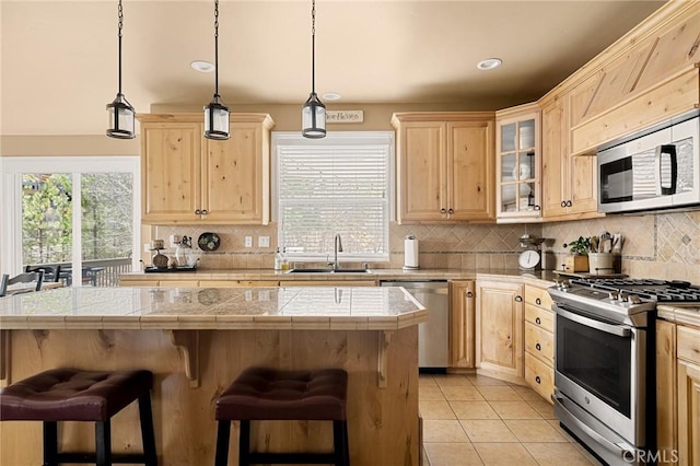 kitchen featuring stainless steel appliances, a sink, and light brown cabinetry