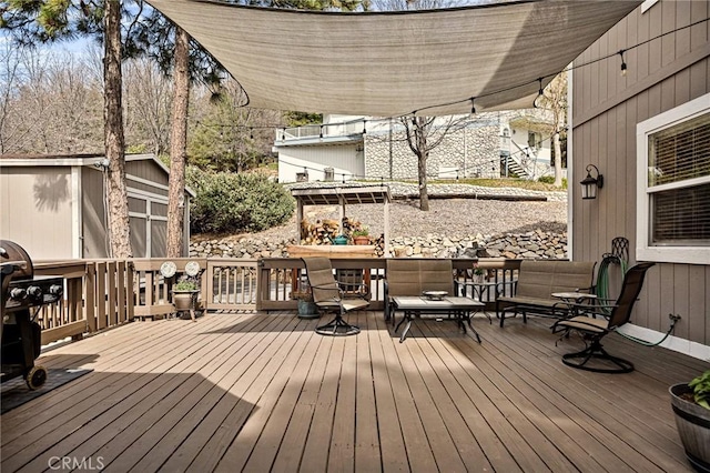 wooden deck with an outbuilding and a storage unit