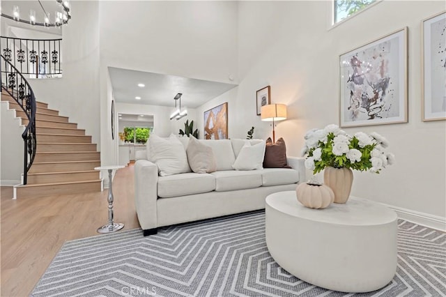 49 W Yale Loop Unit 26, Irvine, CA 92604 - living area with a chandelier, a towering ceiling, stairway, baseboards, and wood finished floors