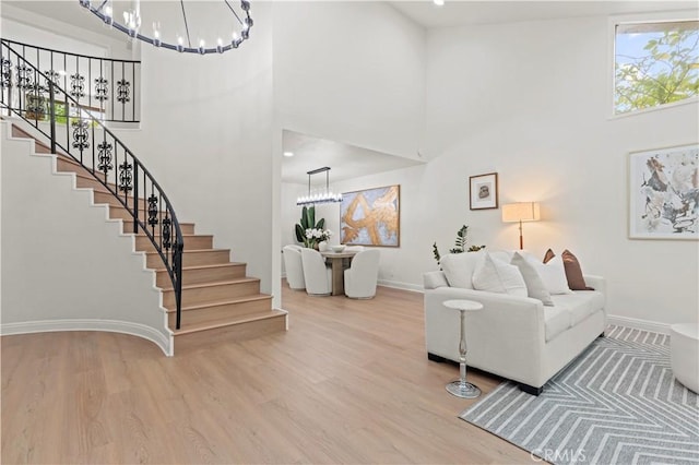 49 W Yale Loop Unit 26, Irvine, CA 92604 - living area featuring a chandelier, a high ceiling, stairs, and wood finished floors