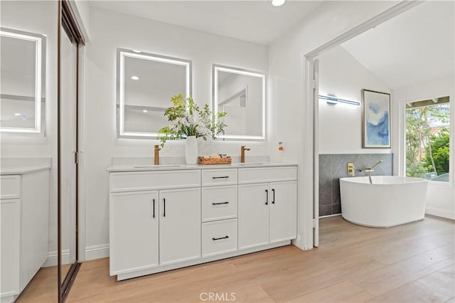 49 W Yale Loop Unit 26, Irvine, CA 92604 - full bath with double vanity, wood finished floors, a soaking tub, recessed lighting, and lofted ceiling