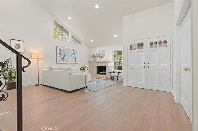 49 W Yale Loop Unit 26, Irvine, CA 92604 - living area with light wood finished floors, a fireplace, high vaulted ceiling, baseboards, and stairs