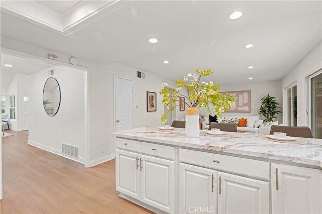 49 W Yale Loop Unit 26, Irvine, CA 92604 - kitchen with light wood finished floors, white cabinetry, recessed lighting, light stone counters, and open floor plan