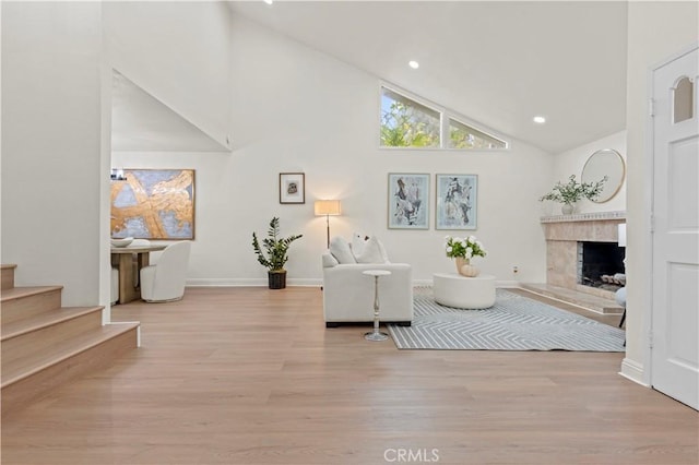 49 W Yale Loop Unit 26, Irvine, CA 92604 - living area with wood finished floors, stairway, high vaulted ceiling, a fireplace, and recessed lighting