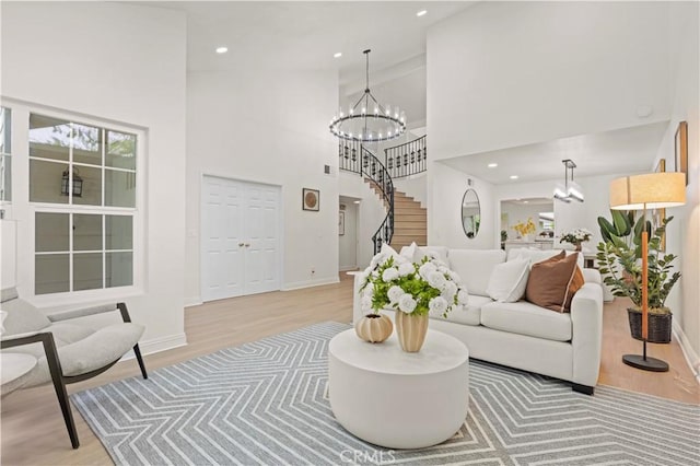 49 W Yale Loop Unit 26, Irvine, CA 92604 - living area with light wood-style floors, a chandelier, a high ceiling, baseboards, and stairs