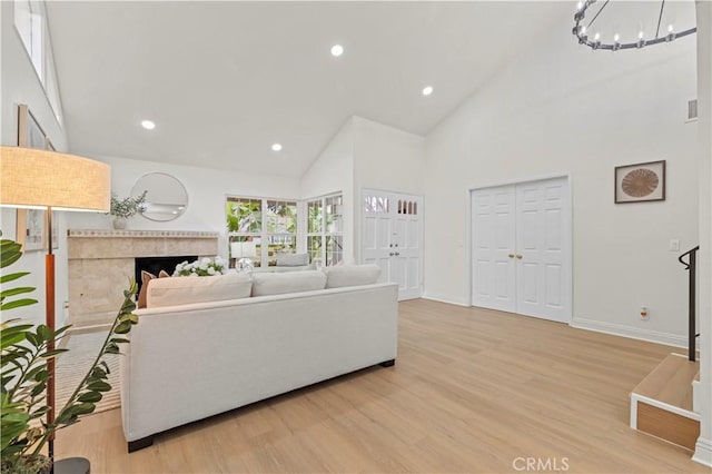 49 W Yale Loop Unit 26, Irvine, CA 92604 - living area featuring high vaulted ceiling, light wood-type flooring, baseboards, a chandelier, and recessed lighting