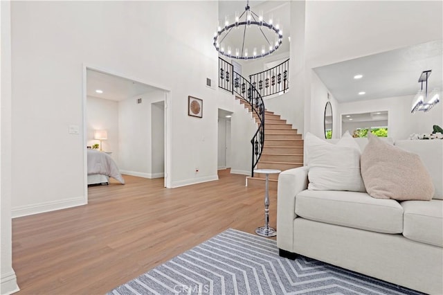 49 W Yale Loop Unit 26, Irvine, CA 92604 - living area featuring a chandelier, wood finished floors, baseboards, a towering ceiling, and stairway