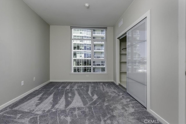 carpeted empty room featuring visible vents and baseboards