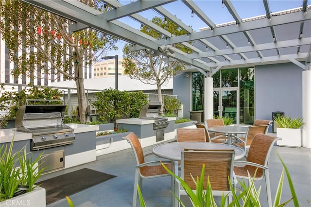 view of patio with a pergola, area for grilling, exterior kitchen, and outdoor dining space