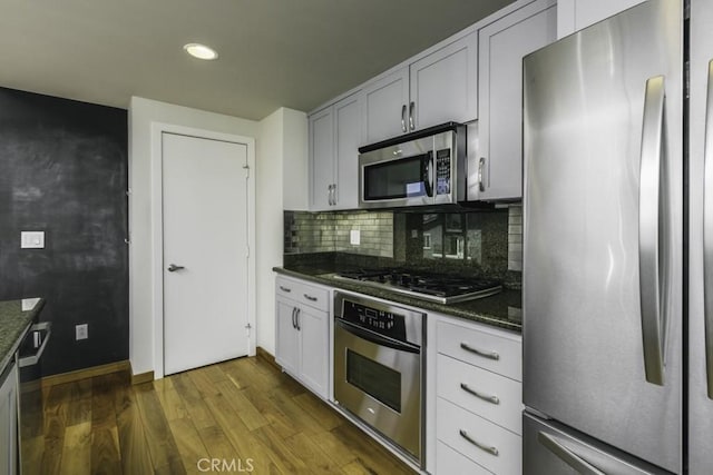 kitchen featuring tasteful backsplash, baseboards, recessed lighting, dark wood finished floors, and stainless steel appliances