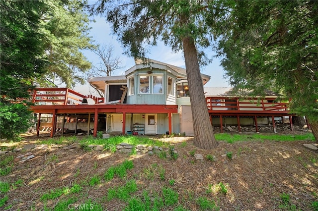 rear view of property with a wooden deck and a sunroom